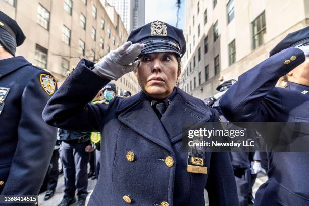 Members of the NYPD salute as the casket of fallen NYPD officer Wilbert Mora is brought out of St. Patrick's Cathedral in Manhattan on February 2,...