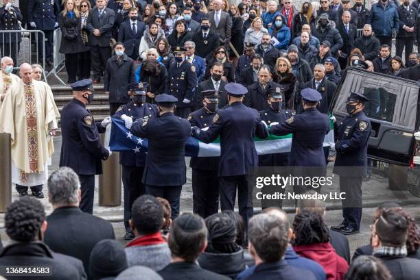 Pallbearers fold the Americian flag that covered the casket of Officer Wilbert Mora following Mora's funeral at St. Patrick's Cathedral, on February...