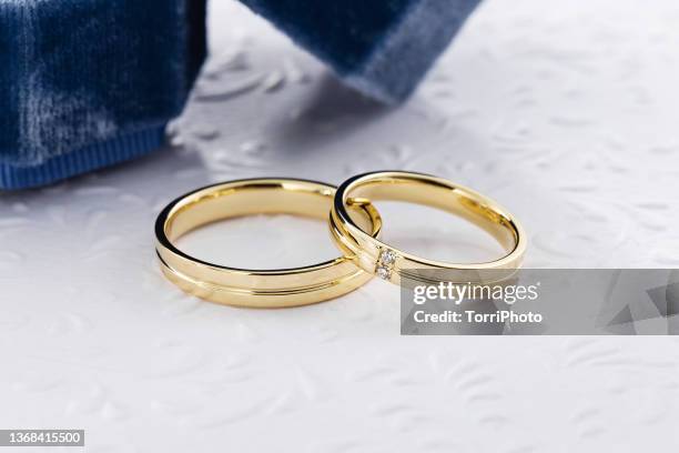 pair of modern gold wedding rings decorated with diamonds - trauringe gold stock-fotos und bilder