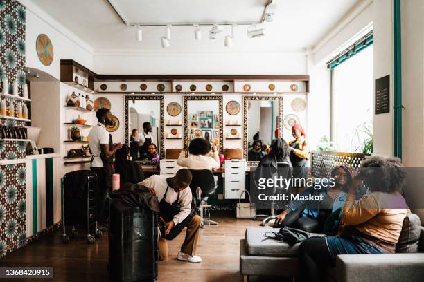 multiracial barbers and customers in hair salon - hairdressers black woman stockfoto's en -beelden