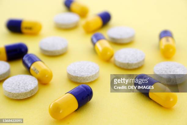 medicine capsules on yellow background - mdma stock pictures, royalty-free photos & images