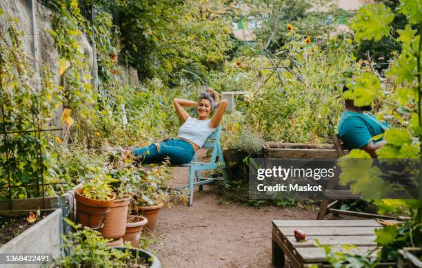 female and male environmentalists resting in urban farm - community garden stock-fotos und bilder