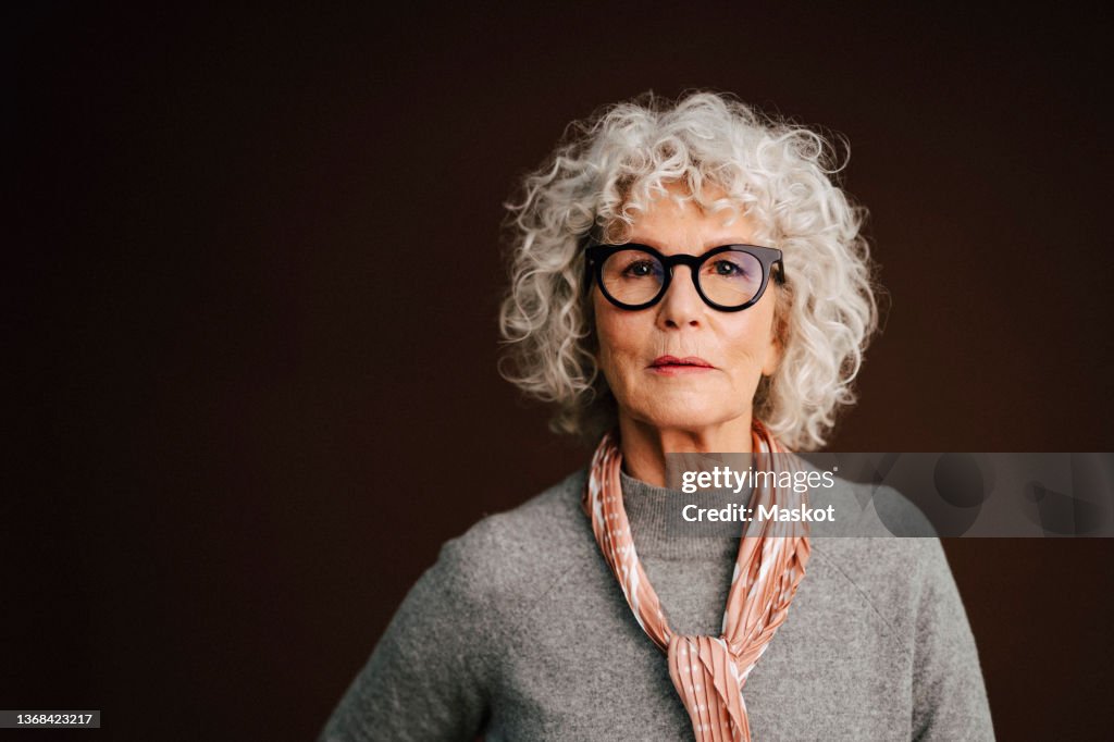 Portrait of confident elderly woman in studio