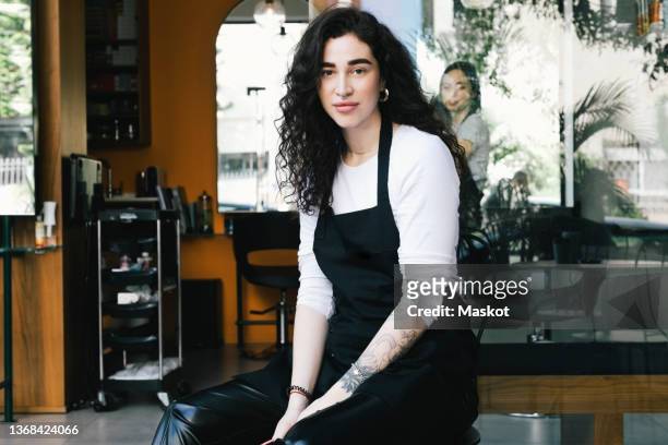 portrait of female owner sitting against hair salon - israeli woman stock pictures, royalty-free photos & images