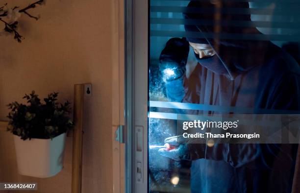 burglar breaking into house - einbruch stock-fotos und bilder