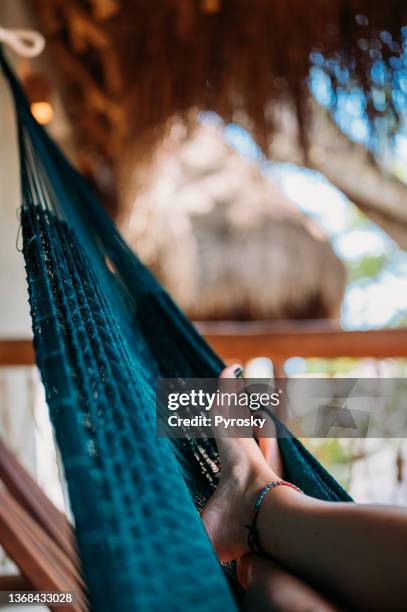 close-up of female's feet in a hammock, in a bamboo house - heavenly resort stock pictures, royalty-free photos & images