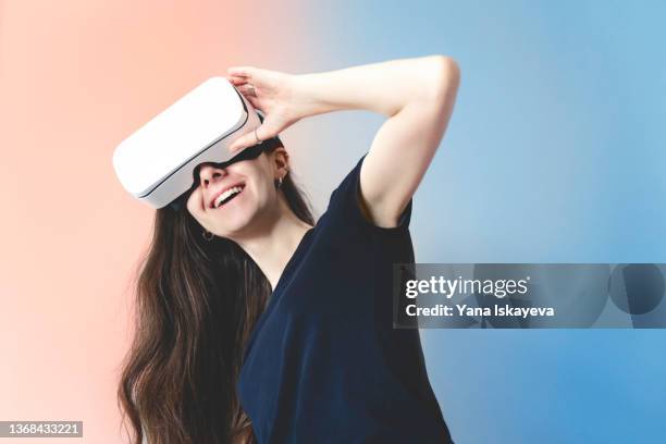 young woman is enjoying virtual reality glasses, smiling happily - realite virtuelle photos et images de collection