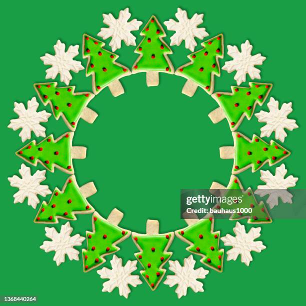 christmas tree and snowflake: christmas wreath created using festive decoratively iced christmas cookies - cookie decorating stock illustrations