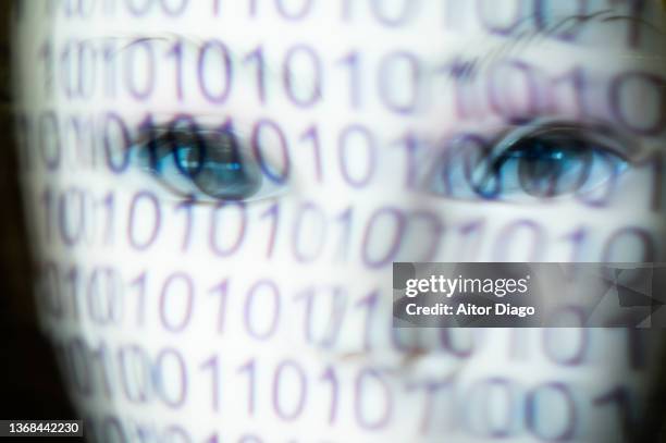 person with a white mask and a binary code on the mask. represents man and machine, programming, the virtual world and the future. moved image. - mystery machine stock pictures, royalty-free photos & images