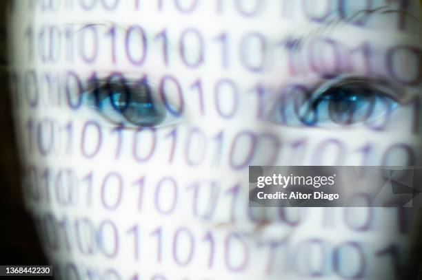 person with a white mask and a binary code on the mask. represents man and machine, programming, the virtual world and the future. moved image. - scary robot stock pictures, royalty-free photos & images