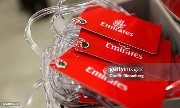 Emirates Airline-branded luggage tags sit on display at the company's check-in area at Heathrow airport, operated by BAA Ltd., in London, U.K., on...