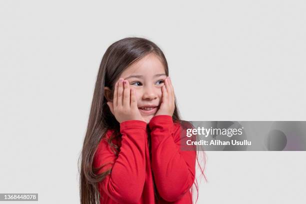porträt eines glücklichen mädchens mit den händen auf den wangen - child shock studio stock-fotos und bilder