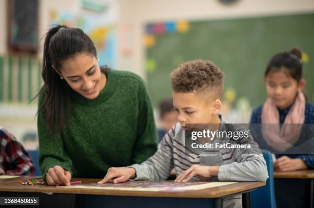 teacher helping a student with geography - student and teacher bildbanksfoton och bilder