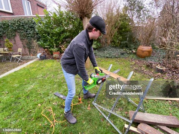 chainsawing young man - sawing stock pictures, royalty-free photos & images