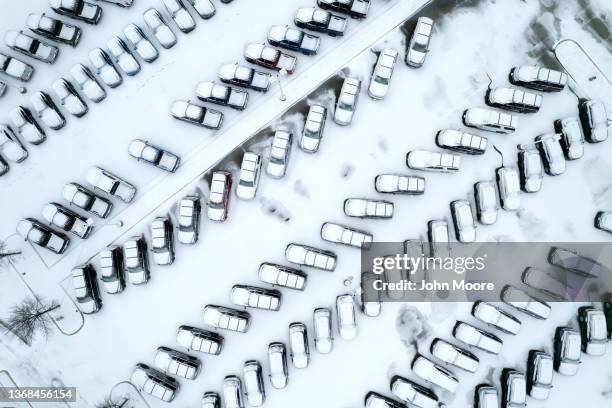 In an aerial view, cars sit covered in snow and ice at a Ford car dealership on February 03, 2022 in Irving, Texas. A winter storm blanketed many...