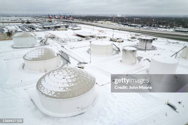 In an aerial view, fuel tanks sit covered in snow and ice at an Exxon Mobile Pipeline facility on February 03, 2022 in Irving, Texas. A winter storm...