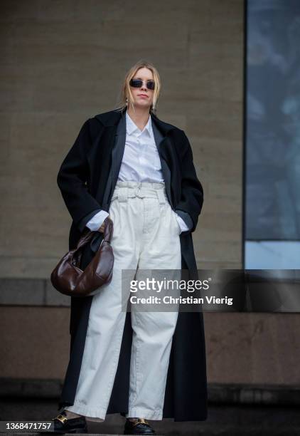 Hanna Stefansson seen wearing brown bag, white pants, black coat outside Mark Kenly Domino Tan during Copenhagen Fashion Week Autumn/Winter 2022 on...