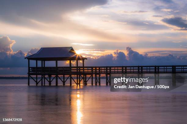 the pass,silhouette of pier over sea against sky during sunset,pass christian,mississippi,united states,usa - mississippi beach stock pictures, royalty-free photos & images