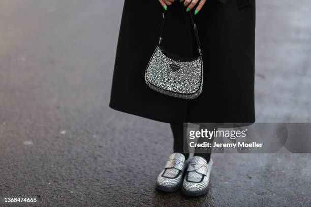Sonia Lyson wearing Prada mini Cleo bag and sparkling black loafer, The Frankie Shop black coat on February 02, 2022 in Berlin, Germany.