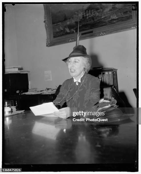 View of US Representative Jeannette Rankin as she reads a statement, seated at a conference table, Washington DC, February 7, 1939. The first woman...