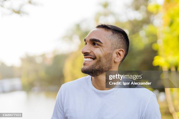 young smiling athlete in public park - casual male stockfoto's en -beelden