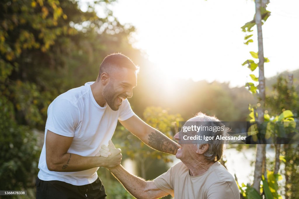 Young and old athlete greet each other in the natural park