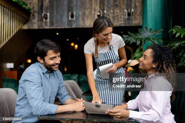 clientes en un restaurante haciendo preguntas sobre el menú a la camarera - camarero fotografías e imágenes de stock