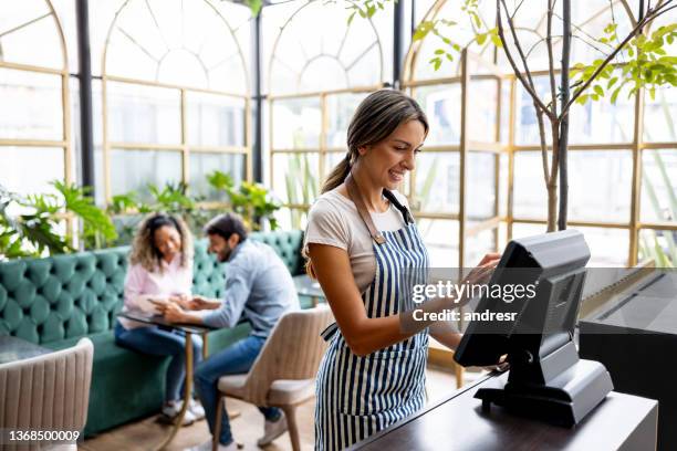 happy waitress working at a restaurant and smiling - entering restaurant stock pictures, royalty-free photos & images