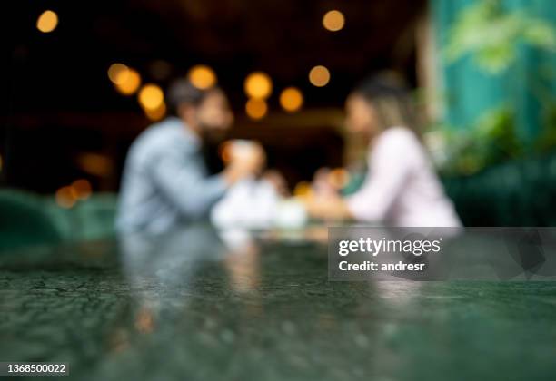 blurry picture of two people at a restaurant - romance background stock pictures, royalty-free photos & images