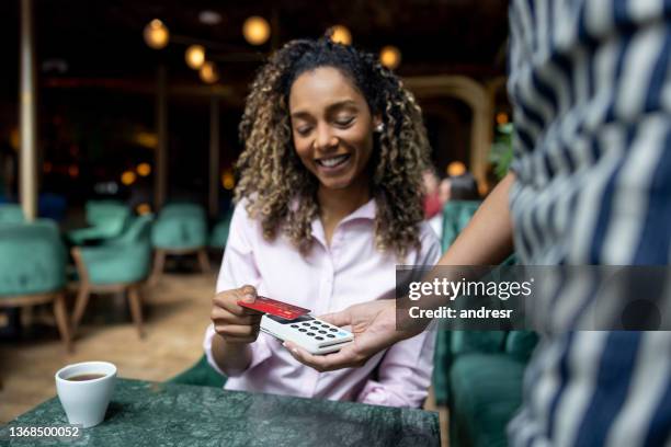 woman paying by card at a restaurant making a contactless payment - dinner open cafe stock pictures, royalty-free photos & images