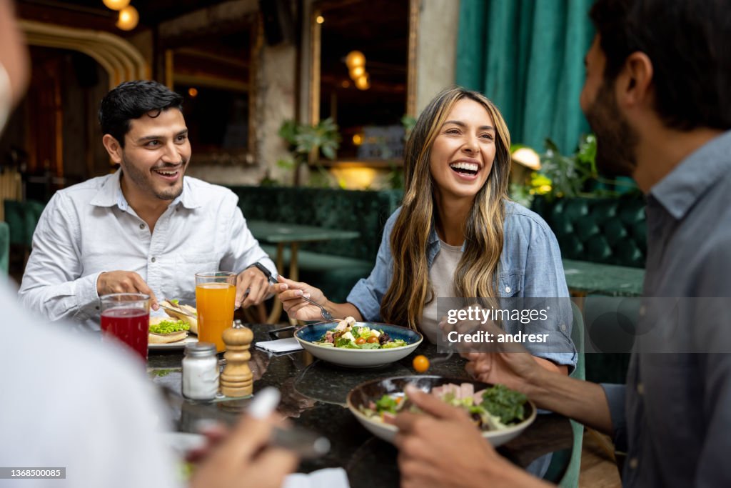 Happy group of friends having lunch together at a restaurant