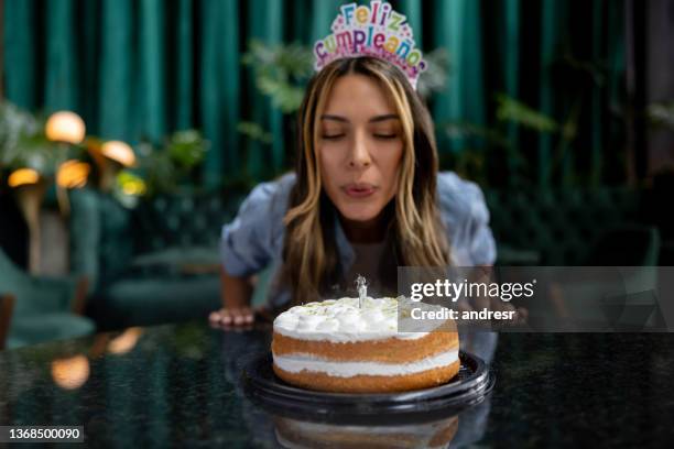 mulher comemorando seu aniversário e soprando as velas em seu bolo - soprando - fotografias e filmes do acervo