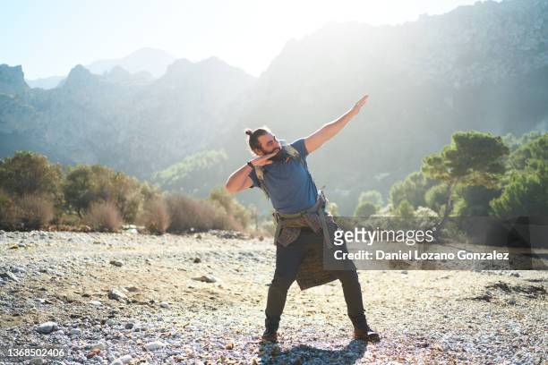 smiling traveling man showing dab gesture in highlands - dab dance stock pictures, royalty-free photos & images