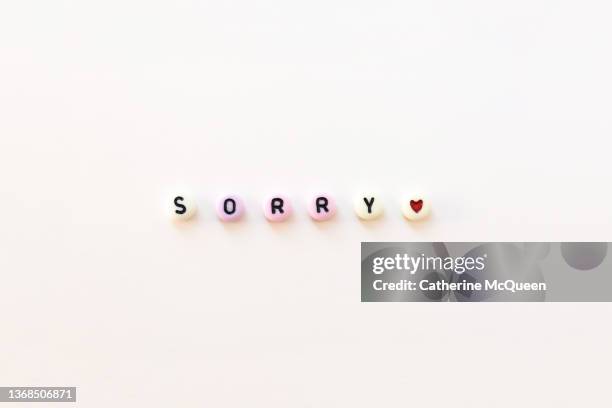 the word “sorry” written in beads on white background - infidelity bildbanksfoton och bilder