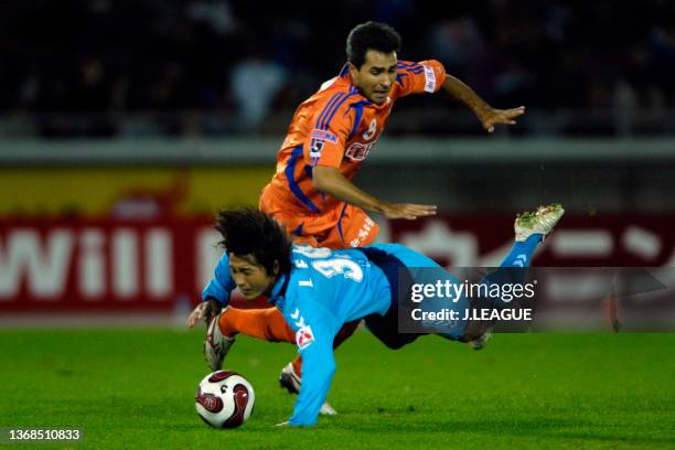 Atsuhiro Miura of Yokohama FC is challenged by Silvinho of Albirex Niigata during the J.League J1 match between Yokohama FC and Albirex Niigata at...