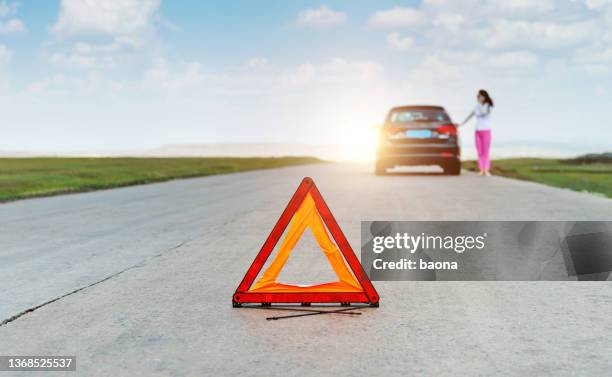 red triangle sign behind the broken car - triangle road stock pictures, royalty-free photos & images