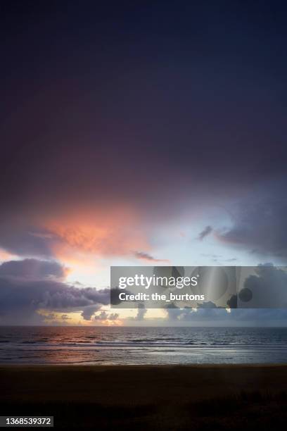 dramatic sky with cloud hole during sunset at the sea - eye of the storm stock pictures, royalty-free photos & images