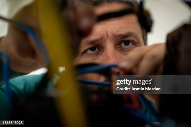 male technician working on cables in server room - telefoondraad stockfoto's en -beelden