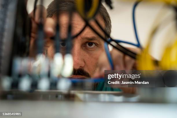 male technician working on cables in server room - chaotic system people foto e immagini stock