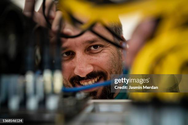 male technician working on cables in server room smiling - chaotic system people foto e immagini stock