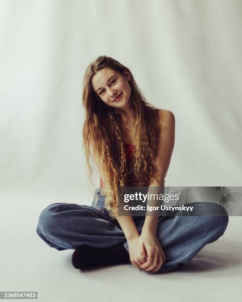 young beautiful woman sitting on the floor smiling - form fitted stock pictures, royalty-free photos & images