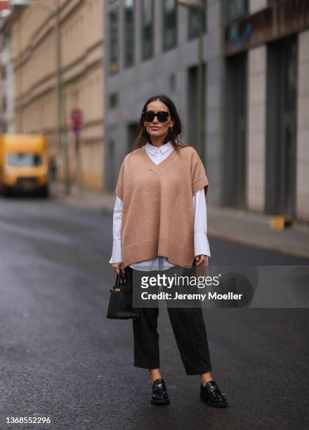 Anna Schürrle wearing Prada black loafer, Comma Fashion white blouse, beige vest and grey Comma Fashion pants, Bottega Veneta brown shades, Hermes...