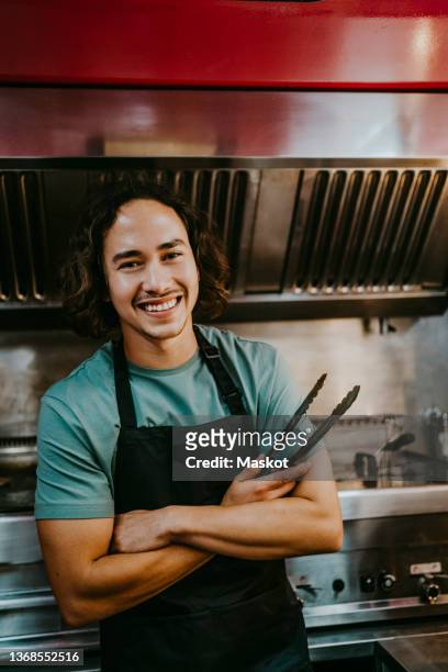 portrait of male chef with serving tong in food truck - grillzange stock-fotos und bilder