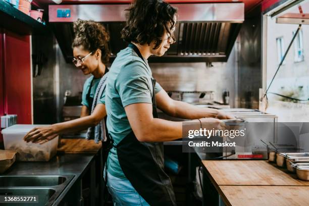 male and female business owners working together in food truck - furgone ambulante foto e immagini stock