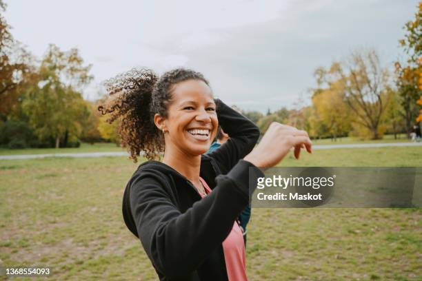 portrait of happy woman in park - mid adult stock pictures, royalty-free photos & images