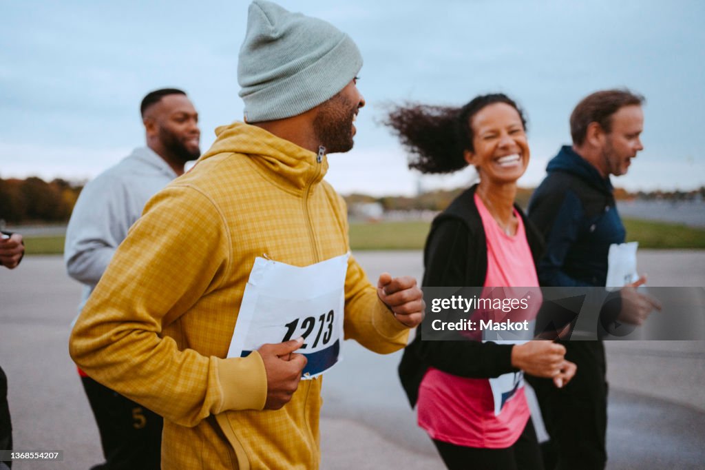 Cheerful male and female friends running in park
