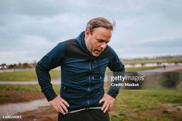 exhausted man taking break in park - draining stock pictures, royalty-free photos & images