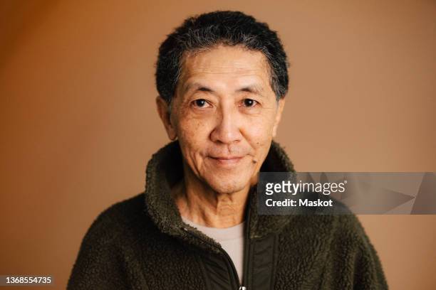 portrait of senior man over brown background - old asian man foto e immagini stock