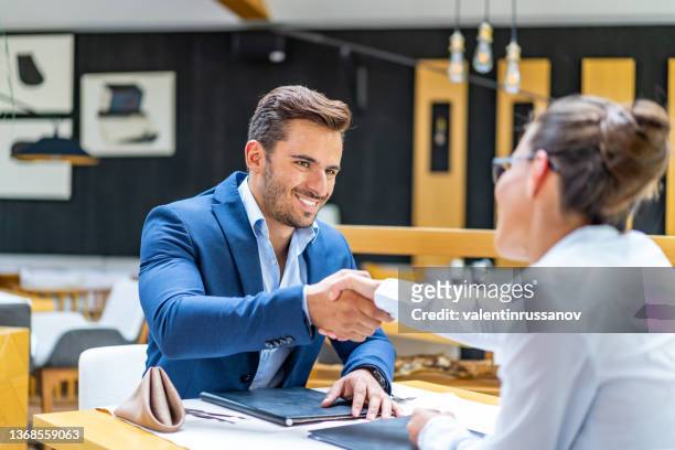 business people handshake, sitting on a table in a restaurant, having  business lunch - 辦公室戀情 個照片及圖片檔
