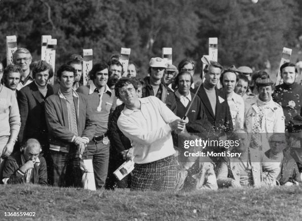 Spectators look on with periscopes as Hale Irwin from the United States plays an iron shot out of the sand bunker on to the green at the 18th hole...